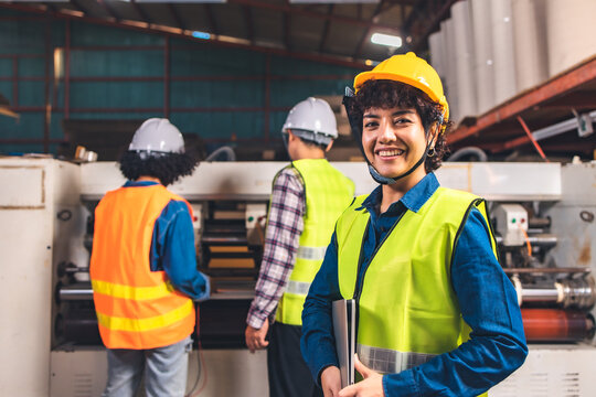 Engineer asian worker wearing safety helmet and vest holding clipboard and take note or tablet in the automotive part warehouse.Products and corrugated cardboard. 