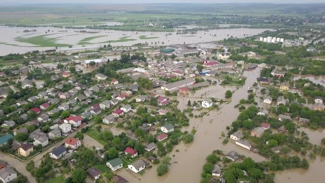 GALYCH, UKRAINE - JUNE 24, 2020: Flooded neighborhood street. Major flooding leaves city, underwater, entire community. Homes, houses overflowing water, insurance needed. Rescue teams helping people