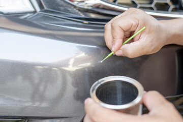 Close up hand a man holding together and paint can for preliminary car paint repair from an accident : basic car service that can be made by yourself