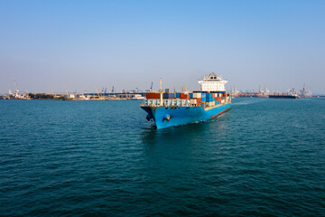 Obraz premium container cargo ship carrying commercial container import export business delivery service commerce cargo logistic and transportation international by container ship in green sea worldwide