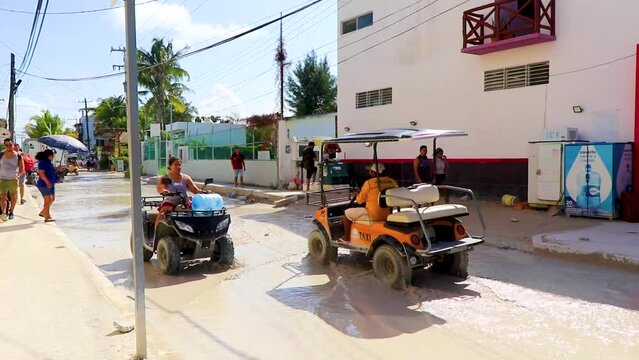 Golf cart buggy cars carts muddy street village Holbox Mexico.