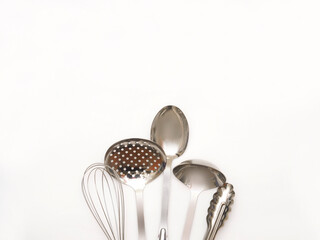 Set of metal kitchen utensils isolated on white background with copy space. Stainless steel kitchen appliances.