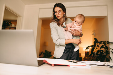 Professional interior designer holding her baby in her home office