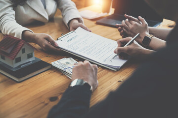 Business woman and young couple signing agreement for buying house. Bank manager and real estate concept.