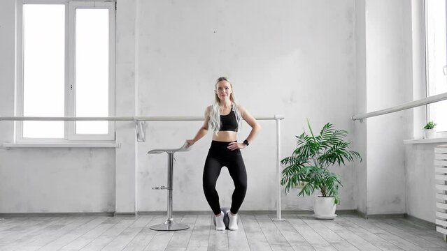 Athletic girl in sportswear training indoors. Sporty fit girl doing fitness aerobic exercises. Healthy lifestyle concept. Slim female. 4K, UHD