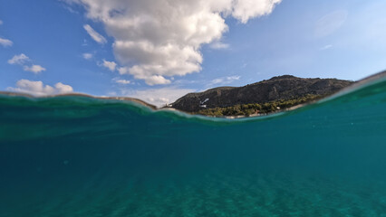 Underwater split photo taken from beautiful emerald bay and beach of Kapsali and famous Monastery of Saint John at the background, Kythira island, Ionian, Greece