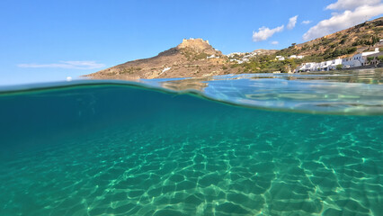 Fototapeta premium Underwater split photo taken from beautiful emerald bay and beach of Kapsali overlooking famous castle of Kythira island, Ionian, Greece