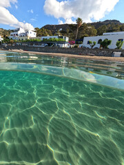 Underwater split photo taken from beautiful emerald bay and beach of Kapsali and famous Monastery of Saint John at the background, Kythira island, Ionian, Greece