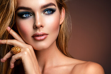 Photo of young woman with style make-up. Portrait of blonde woman with a beautiful face. Closeup face with stylish blue makeup. Fashion model with long hair, studio shot. - Powered by Adobe