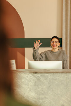 Cheerful female receptionist greeting  a client at the front desk