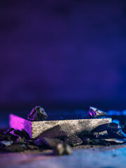 Black charcoal on a neon background. Charcoal podium black background