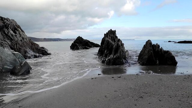 Hannafore beach at low water, a calm video of waves lapping around the rocks on the beach at west Looe Cornwall