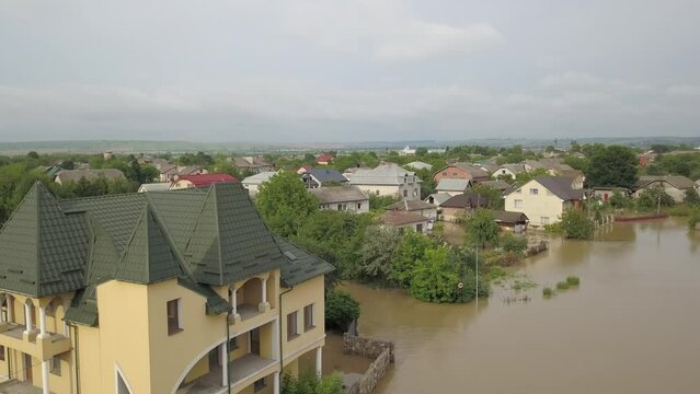 GALYCH, UKRAINE - JUNE 24, 2020: Flooded neighborhood street. Major flooding leaves city, underwater, entire community. Homes, houses overflowing water, insurance needed. Rescue teams helping people