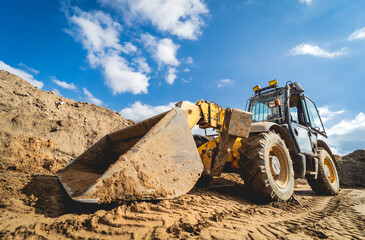 Obraz premium Wheel loader excavator works at construction site