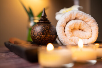Obraz na płótnie Canvas Close up wooden Gun Sha, rolled towel, stone, flower and candle on the tray over wooden background. Facial spa set, wellness well-being lifestyle concept.