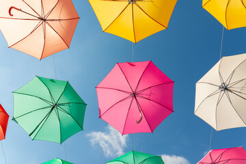 Colourful umbrellas urban street decoration, hanging colourful umbrellas on the blue sky, tourist attraction