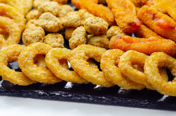 Southern fried and roast chicken bites, onion rings and mozzarella stick served on the stone plate