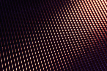 Corrugated texture. Neon light background. Grooved metal surface. Golden blue color gradient glow reflection on parallel lines pattern dark black abstract overlay.