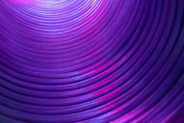 Ridged texture. Blur glow background. Fluorescent embossed tunnel wall. Iridescent radiance. Defocused neon purple pink color light on curved corrugated abstract overlay.