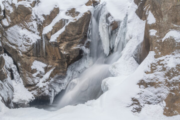 Fototapeta na wymiar Winter landscape of Boulder Falls captured with motion blur and framed by ice, Colorado, USA