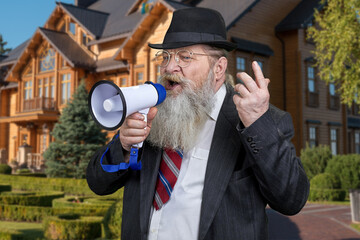 Emotional senior businessman talking into megaphone standing outdoors.