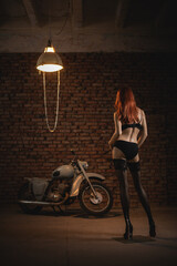 Beautiful woman dummy in leather bodysuit and stockings on the old motorcycle background in showcase concept.