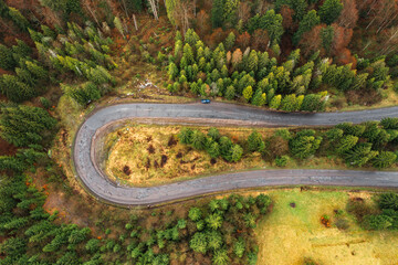 steep and dangerous turns on the road, serpentine roads in the woods, top view of the serpentine and forest.