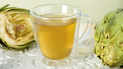 Artichoke tea glass cup. Raw artichoke vegetables with herbal beverage.
