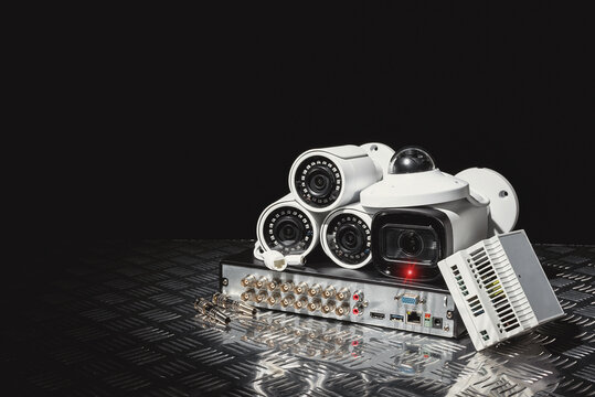 Modern white security cameras and video recorder close up. Video surveillance equipment background with copy space.