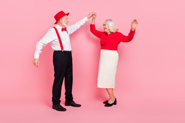 Full length body size view of attractive cheery gray-haired couple dancing rest isolated over pink...