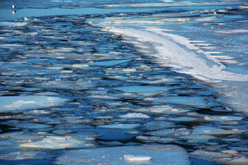 Winter nature background with blocks of ice on frozen water in spring. Abstract background of drifting ice on water © Nataliia