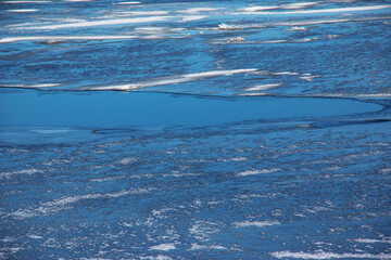 Winter nature background with blocks of ice on frozen water in spring. Abstract background of drifting ice on water © Nataliia