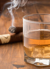 Cigars and whiskey on a wooden table. Copy space.