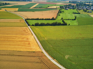 Aerial drone view of green and yellow fields in Normandy, France