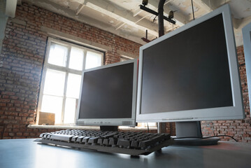 A blank screen computer monitors with copy space on the metal table background.