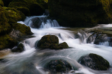 Fototapeta na wymiar Fluss fließt über kleine Felsen