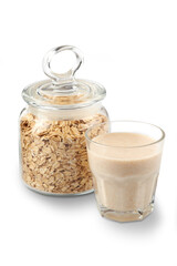 Oat milk in a glass and jar with oatmeal , isolated on a white.  Milk substitute, milk for vegetarians.