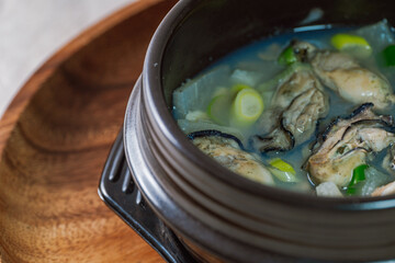 Gulguk, Korean style oyster soup : made by boiling fresh oysters with radish, bean curd, onion, anchovy, and mushroom. Add brown seaweed and chive to the soup to remove the fishy smell oysters are kno - obrazy, fototapety, plakaty