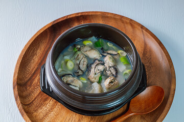 Gulguk, Korean style oyster soup : made by boiling fresh oysters with radish, bean curd, onion, anchovy, and mushroom. Add brown seaweed and chive to the soup to remove the fishy smell oysters are kno - obrazy, fototapety, plakaty