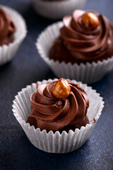 Meringue, pavlova chocolate cupcakes with cream and nuts