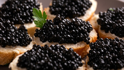 Slices of bread with black caviar on plate
