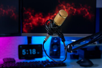 Professional microphone with gamer setup in the background and colored lights
