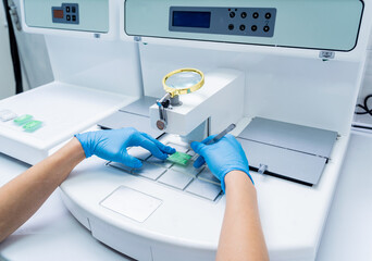 Laboratory assistant works at paraffin wax dispenser tissue embedding machine.