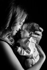 Black and White Photo of Newborn baby on an isolated black background on his mother. Healthcare and medical love lifestyle mother