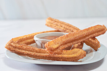 Mexican churros served on a homemade plate.