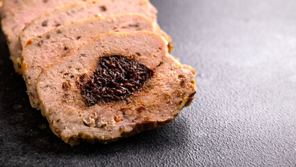 Tasty homemade slices of meatloaf with prunes on rustic background