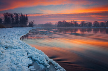 Polska, województwo Lubuskie, rzeka Odra zimą. Kra płynie na wodzie i piękny zimowy wschód...