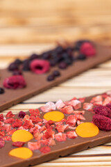 different kinds of chocolate with dried fruits on a wooden board