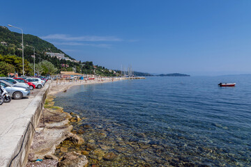 Fototapeta na wymiar Parking lot over Ionian sea shore in Benitses town, Corfu Island, Greece
