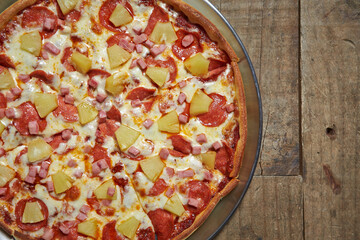 Hawaiian pizza on wooden table 